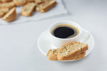A cup of coffee with Italian biscotti cookie. Fresh baked cookie with white cup of coffee and blurred cookies. Close up