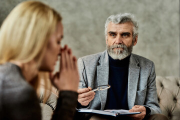 Psychotherapist talking to depressed young caucasian woman