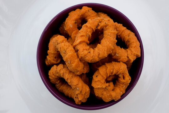 Top view of south indian traditional snack item, evening tea time item Chegodilu or Ring murukku isolated on white background in white plate served during festival