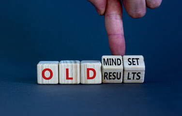 Old mindset and results symbol. Businessman turns wooden cubes and changes words 'old mindset' to 'old results'. Beautiful grey background. Business, old mindset and results concept. Copy space.