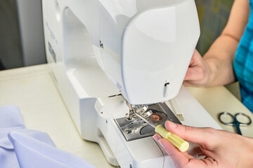 Female hands doing maintenance work on a domestic sewing machine