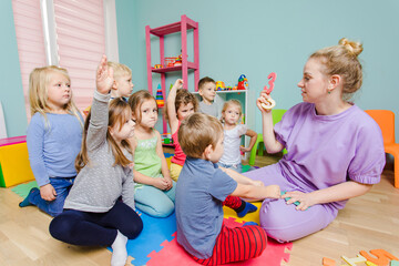 Lovely preschoolers listening young teacher very carefully