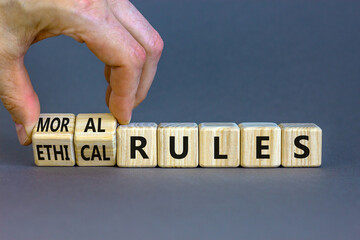 Ethical or moral rules symbol. Businessman turns wooden cubes and changes words 'ethical rules' to...