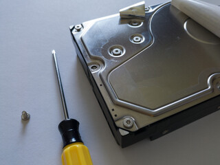 Repair broken computer part for data storage, unscrewed screw and screwdriver, hard disc drive...