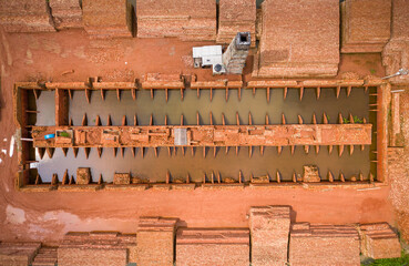 Aerial view of a brick factory with a small furnace chimney along Buriganga river, Keraniganj, Dhaka province, Bangladesh.