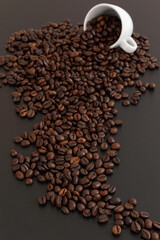 Grains de café sortant d'un tasse sur fond noir