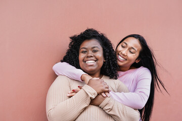 Beautiful latin women hugging each other and smiling - Girls with different body and skin color -...