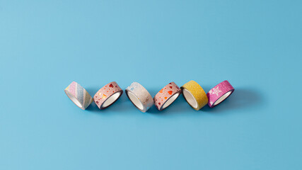 Colorful washi tapes on a pastel blue background. Minimal creative concept. Celebration of...