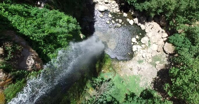Beautiful waterfall in the forest with water reflections. Aerial footage of the waterfall in the green valley. The environment. Best hiking trails. Middle East region. Summer season in Lebanon. Wild