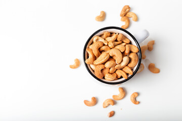 Cashew fruit in the white cup on  white background. Top view.