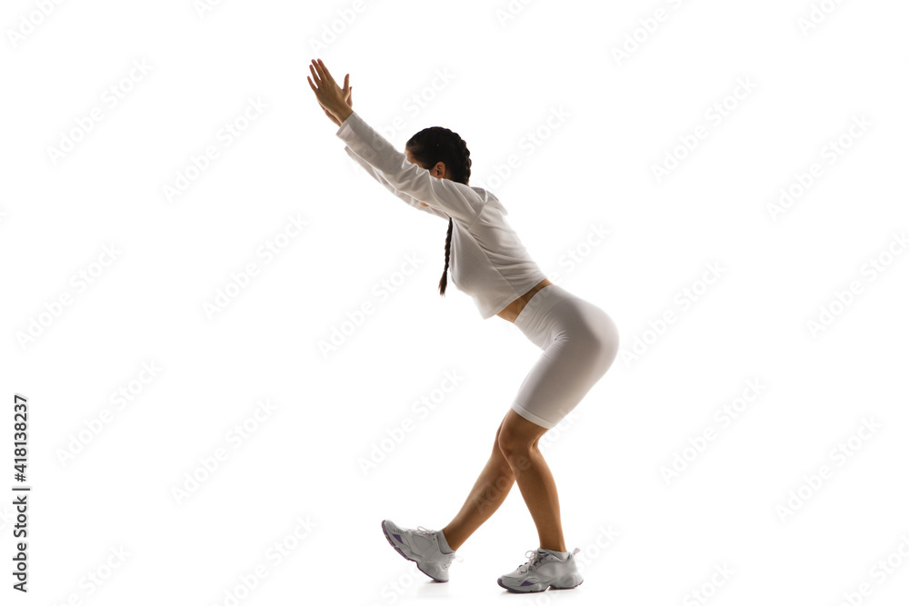 Wall mural stretching. young caucasian female model in action, motion isolated on white background with copyspa