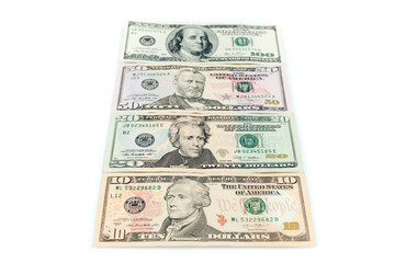Different dollar bills. American dollar banknotes from ten to hundred on white table