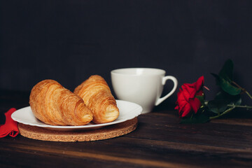 fresh croissant on a plate kitchen utensils coffee cup