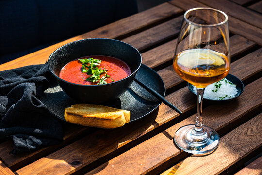 Gazpacho soup with a slice of toast and a glass of rose wine