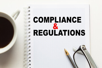 Notepad with inscriptions COMPLIANCE AND REGULATIONS on a white background. business concept.