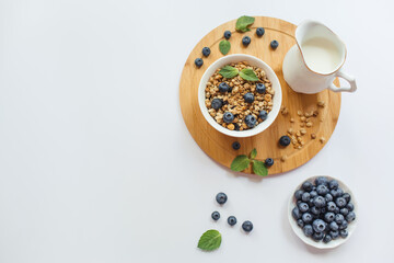 Obraz na płótnie Canvas Breakfast with muesli, fresh berries blueberries on white background. Healthy food concept. Flat lay, top view, copy space