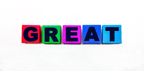 The word GREAT is written on colorful cubes on a light background