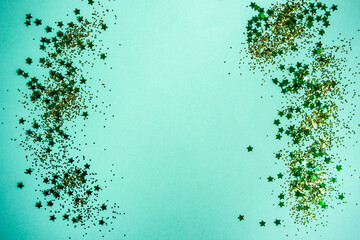 Gold glitter and stars on a turquoise background