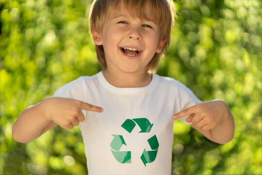 Happy child points fingers at recycle sign on t-shirt