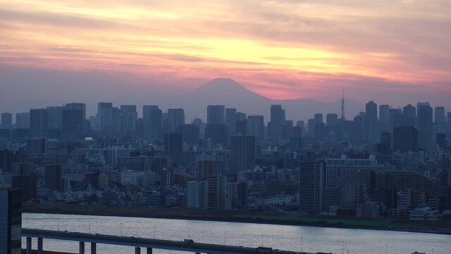 TOKYO, JAPAN : Aerial sunrise CITYSCAPE of TOKYO and MOUNT FUJI. Dawn sky, rising sun and buildings at downtown area. Japanese urban metropolis and nature concept. Time lapse video, night to morning.