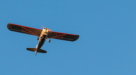 Looking up at small single prop plane with deep blue sky