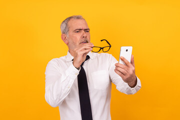 isolated senior adult man with presbyopia or eyestrain looking at phone