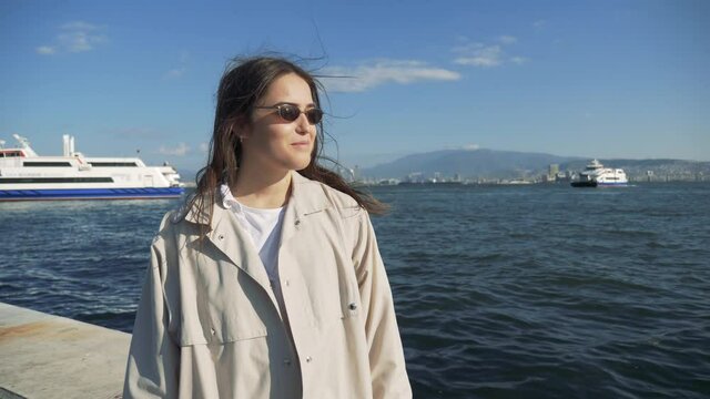 Portrait of a young woman looking standing near the sea on background