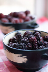 Frozen fruits in a plate on the table. Black blackberry