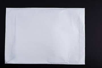 Used white A4 envelope on a black background