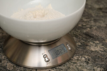 Weighing flour for baking on a digital scale. Preparing bread at home.