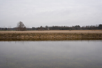 Obraz na płótnie Canvas Flooded meadow in early spring when snow has just melted in the Latvian