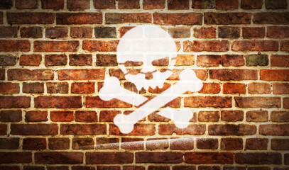 Skull piracy symbol spray painted inscription on the brick wall