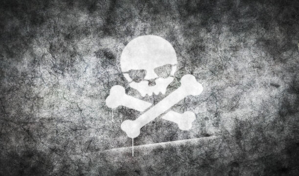 Skull piracy symbol spray painted inscription on the concrete wall