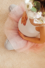 Pregnant woman stay in the room and look at the belly