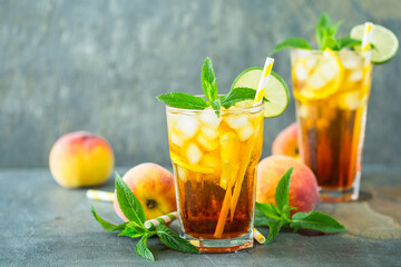 Peach ice tea with ice, lime and mint in the glass
