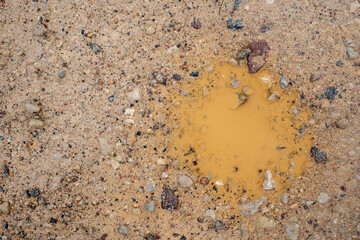 Close-up of the Latvian country road surface where you can see a pit filled with water