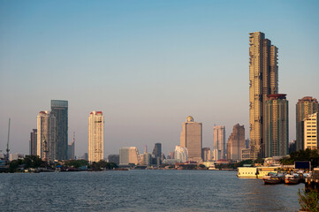 Fototapeta premium Bangkok city with sunshine on high-rise buildings in downtown on Chao Phraya riverside