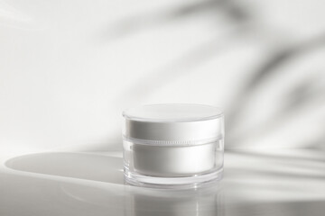 White moisturizer cream, shadow play on trendy white background. Cream jar mockup. Packaging...