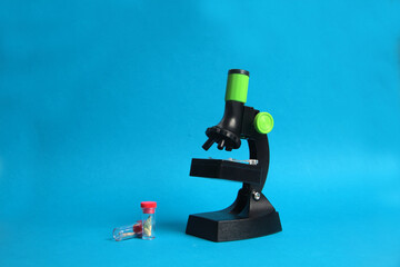 microscope and two test-tubes isolated on blue background. Science concept