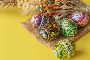 Colorful Easter eggs and palm ona yellow background