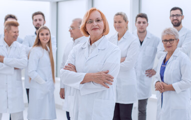 Fototapeta na wymiar senior female doctor standing in front of her colleagues.