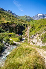 Mountain river and wood bridge in Vanoise national Park valley, French alps