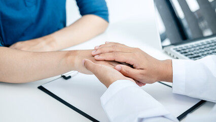 Doctor holding touching hand after reading bad result at clinic