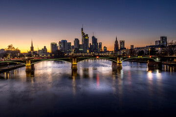 The skyline of Frankfurt at sunset, seen from a bridge at the river Main at a cold day in winter.