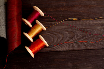 Threads for sewing leather goods, top view. Threads on a wooden background. Sewing tools photo.