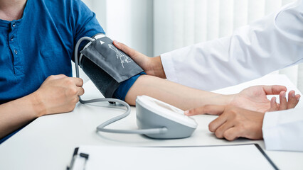 Fototapeta premium Doctor is checking the patient blood pressure in his hospital office