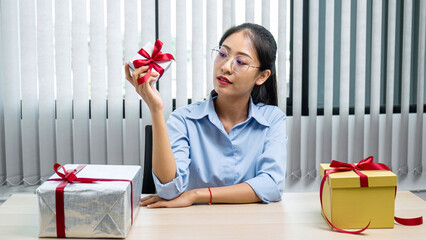 Young asian woman holding a small silver gift box to preparing celebration