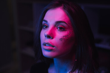 Portrait of a woman in bright makeup at a night party in cyberpunk style. Retro wave portrait of a...