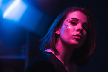 Trendy night portrait of a beautiful woman with beautiful makeup in the style of euphoria, posing...