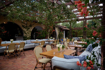 Terrace with blue couches, chairs and tables setting with candles and vases with flowers